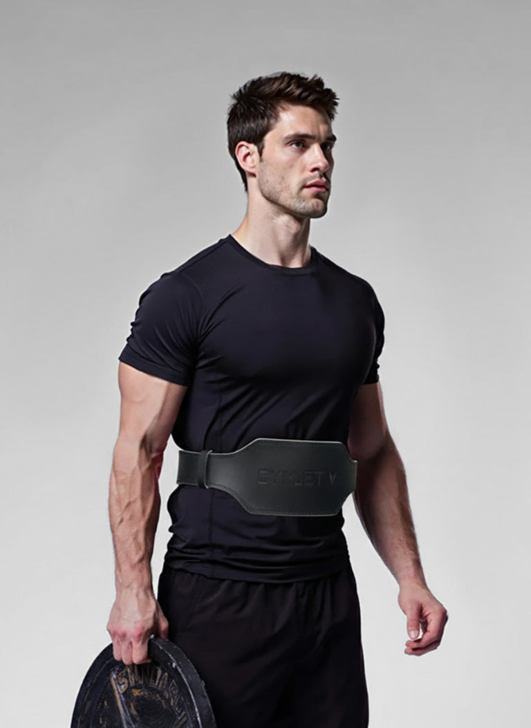 Man holding a weight plate against a gray background
