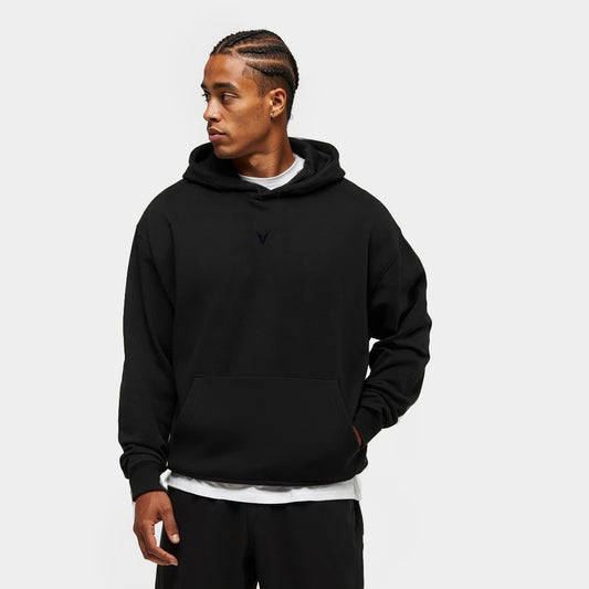 Man wearing a black hoodie on a light gray background