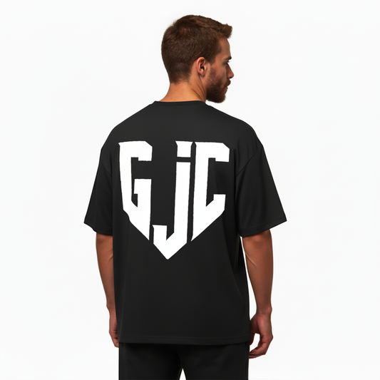 Man wearing a black t-shirt with 'GJC' logo on the back against a white background